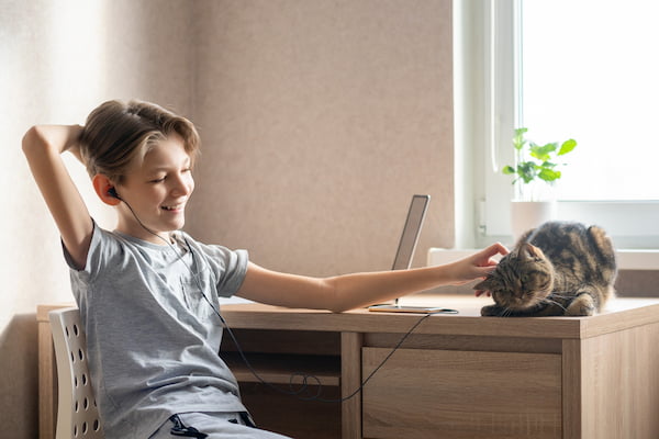 boy listening to music and petting cat